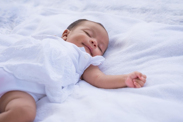 Bebé recién nacido durmiendo en un cojín blanco con espacio para copiar