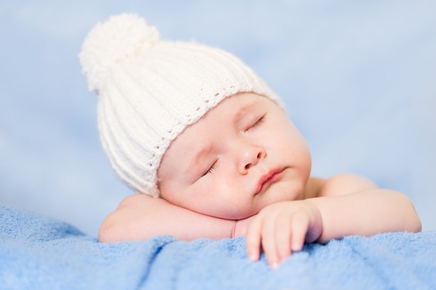 Bebé recién nacido durmiendo pacíficamente vistiendo gorro de punto