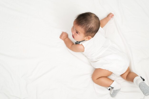 Bebé recién nacido feliz en una cama