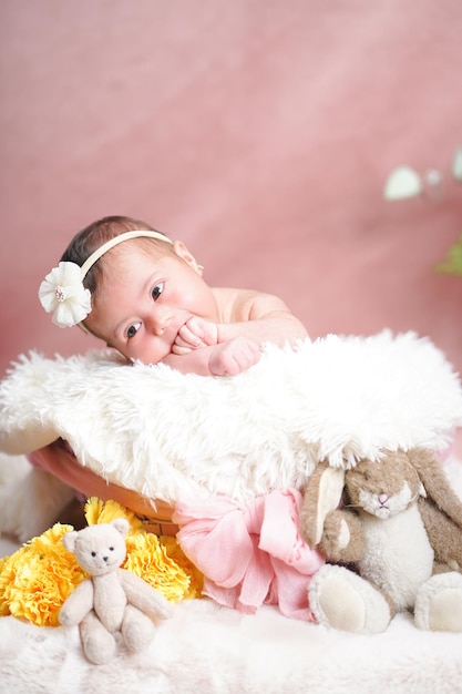 Bebé recién nacido en foto de estudio sobre fondo rosa