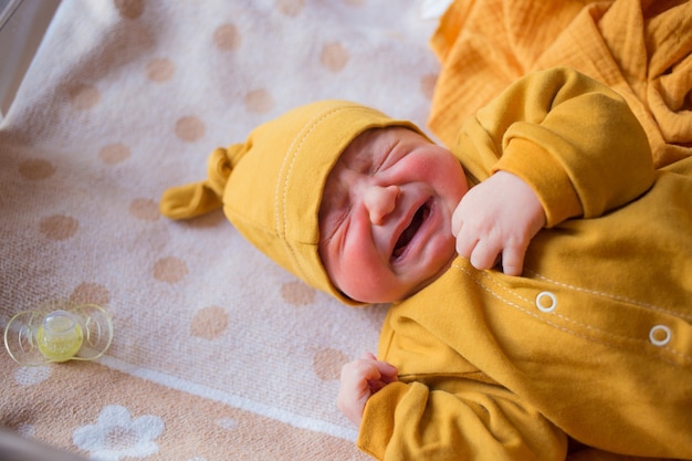 El bebé recién nacido llora de gas, cólicos. Un niño nacido en otoño. Recién nacido en el hospital Un niño nacido en el otoño. Recién nacido en el hospital