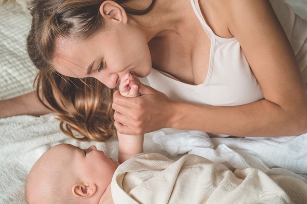 Bebé recién nacido con madre en la cama