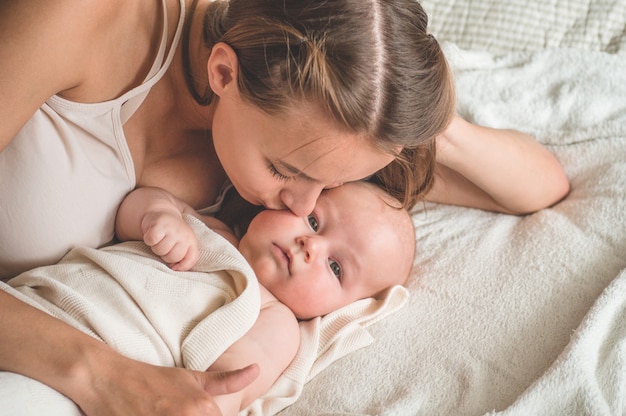 Bebé recién nacido con madre en la cama