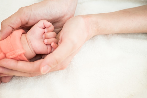 Bebé recién nacido mano en mano madre