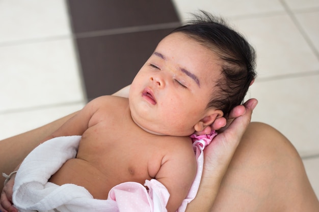 Foto bebé recién nacido en las manos de la madre. madre sosteniendo la cabeza de su bebé recién nacido en las manos.