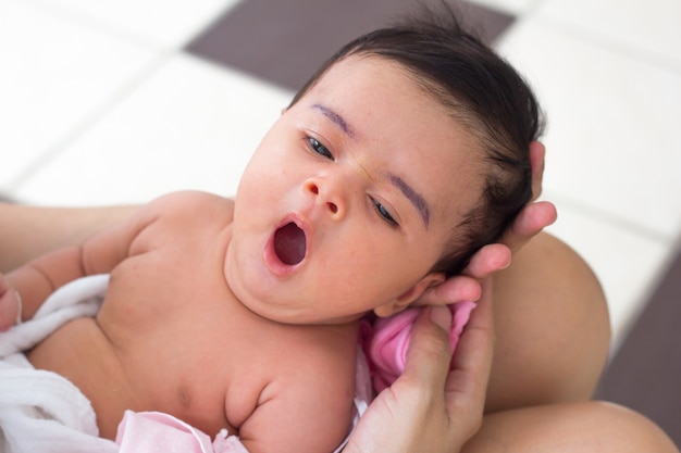 Foto bebé recién nacido en las manos de la madre. madre sosteniendo la cabeza de su bebé recién nacido en las manos.