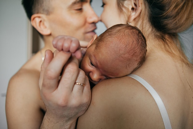 Bebé recién nacido en manos de los padres