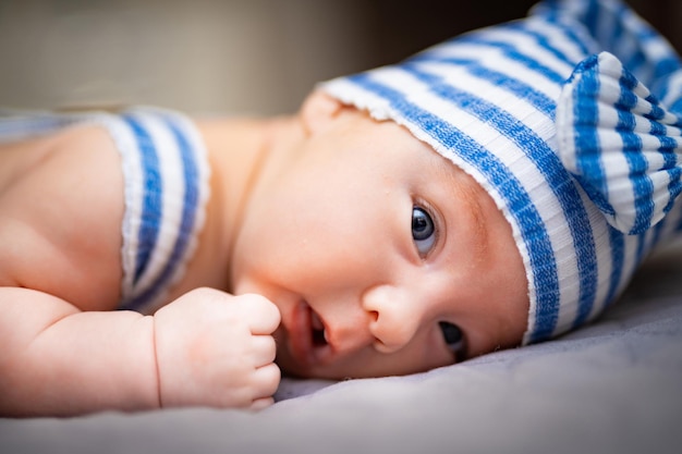 Bebé recién nacido con ropa azul claro mirando a la cámara