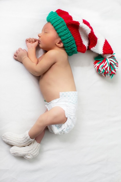 Un bebé recién nacido con un sombrero de gnomo de punto de Navidad