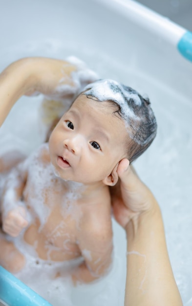 Bebé recién nacido tomando un baño en una ducha