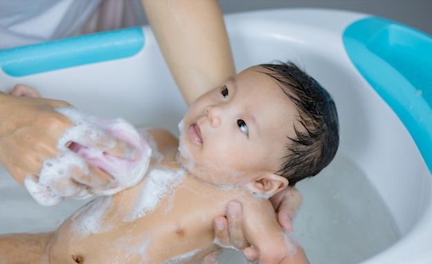 Bebé recién nacido tomando un baño en una ducha