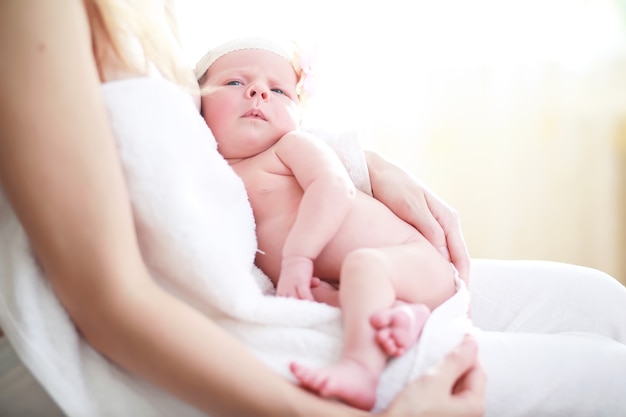 Un bebé recién nacido yace en brazos de su madre. Un hermoso bebé de apariencia europea está durmiendo.