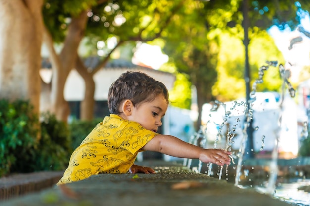 Un bebé refrescándose del calor en la fuente del municipio de Mijas en Málaga Andalucía