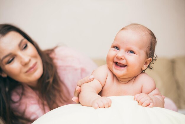 Bebé riendo feliz pasar tiempo con su mamá en el apartamento