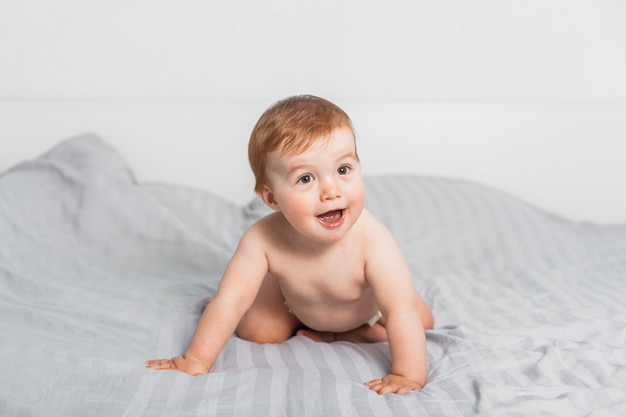 Foto bebé rubio divertido en la cama