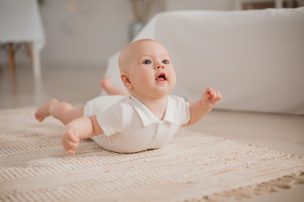 Bebé sano está acostado en el piso de la casa. Materiales ecológicos para el hogar.