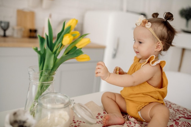 Bebê se senta em uma mesa em uma cozinha escandinava