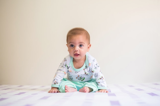 Bebé sentado en la cama