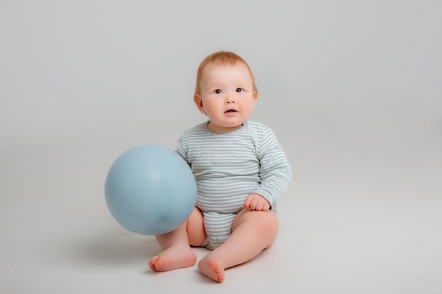 Bebé sentado con un globo azul