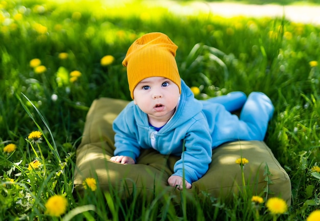 Bebé sentado en la hierba verde y flores amarillas Niño en el prado de diente de león