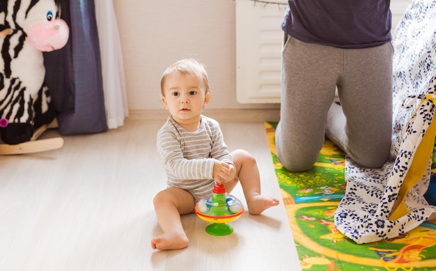 Foto el bebé se sienta en un juguete en casa.