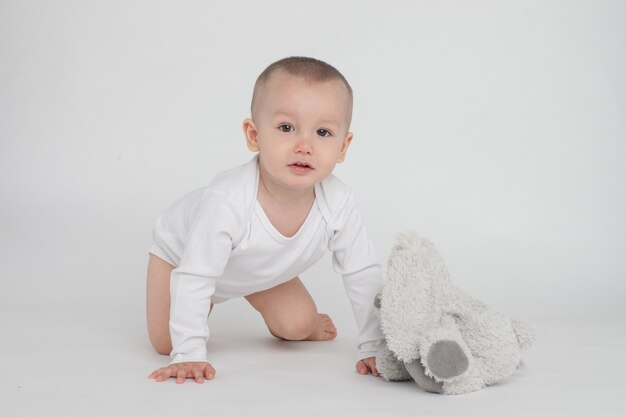 Foto bebé sobre un fondo blanco con un conejito de peluche