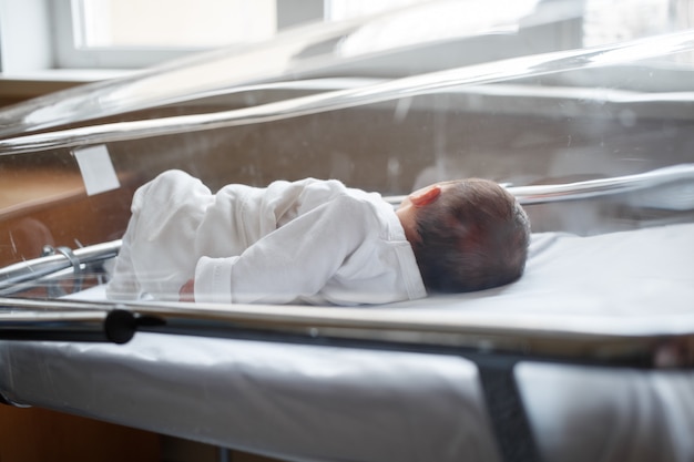 Un bebé solitario está en el hospital. Un bebé recién nacido duerme solo en el boxeo.