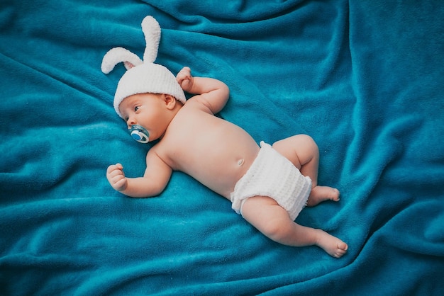 Un bebé con sombrero sobre una manta.