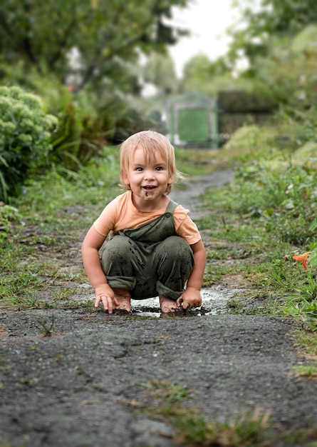 Bebé con una sonrisa encantadora juega en un charco