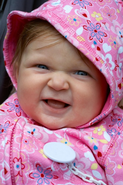 Bebê sorridente no capuz rosa