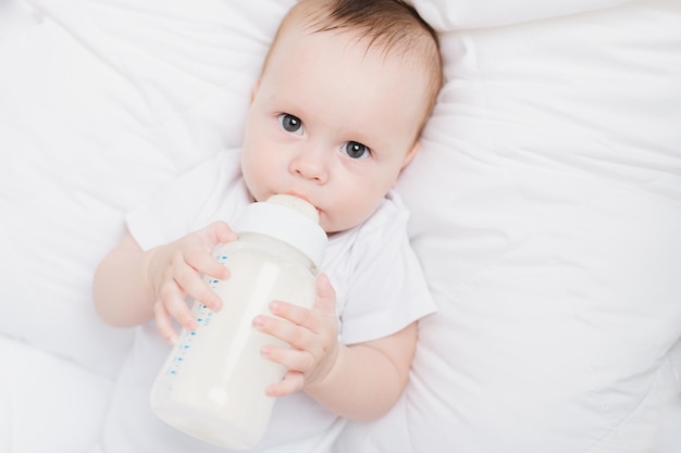 El bebé en su cuna come de un biberón Comida para bebés copyspace Alimentación artificial
