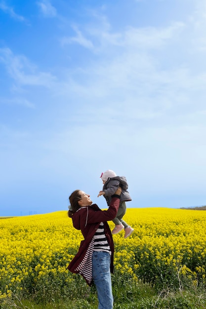 Un bebé y su madre disfrutando de un día soleado en el campo.