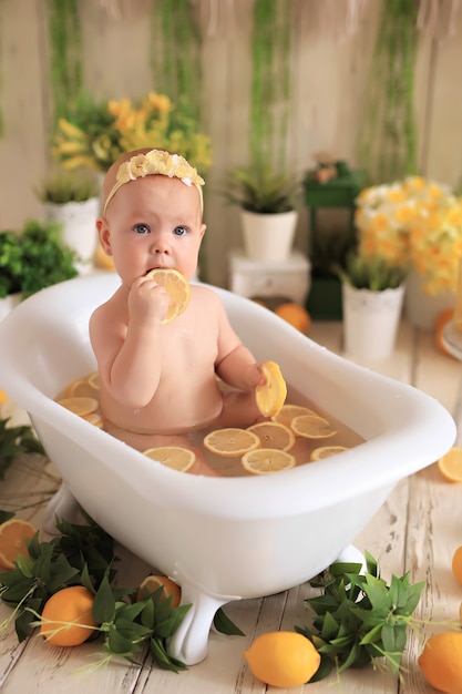 Bebê tomando banho com limões cercado de plantas