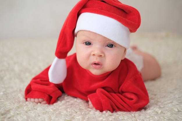 Bebé en traje de santa en blanco