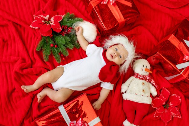 Bebé en un traje de Santa durmiendo sobre un fondo de madera clara