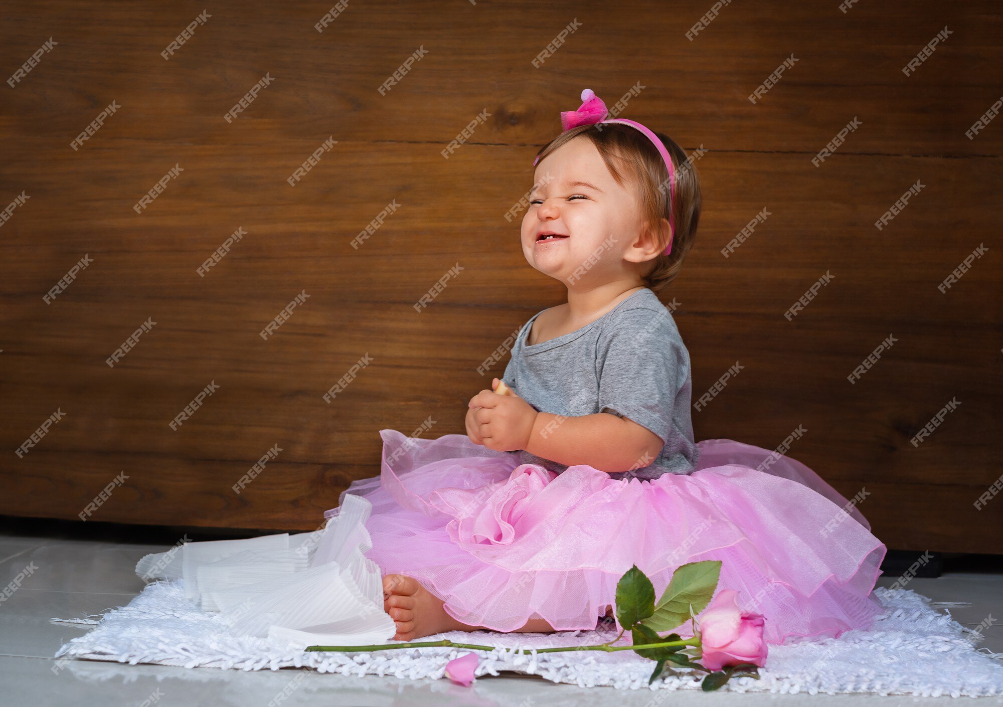 Bebé en el vestido rosa. niño con una rosa y galleta | Foto Premium