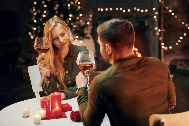 Bebe vinho Jovem casal adorável tem jantar romântico dentro de casa juntos