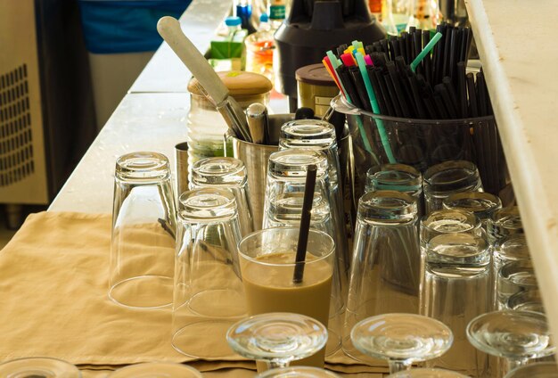 Foto bebedor de vaso y frasco por pajitas en la mesa