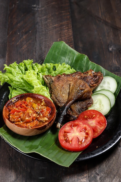 Bebek Goreng Sambal Bawang Frittierte Ente, serviert mit Sambal-Knoblauch-Chili-Sauce und Gemüse