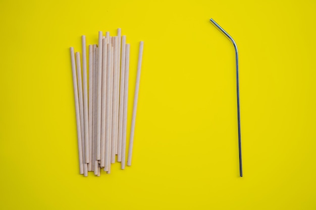 Foto beber acero vs pajitas desechables sobre un fondo amarillo concepto de cero residuos