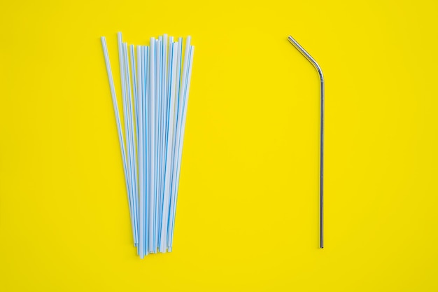 Foto beber aço vs canudos descartáveis em um fundo amarelo conceito de desperdício zero