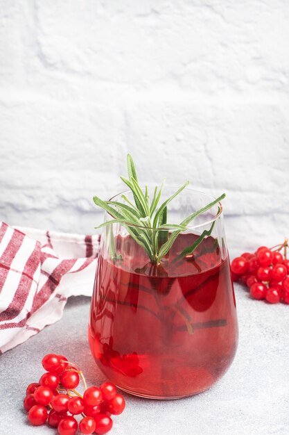 Beber de las bayas de viburnum rojo en copa de vidrio