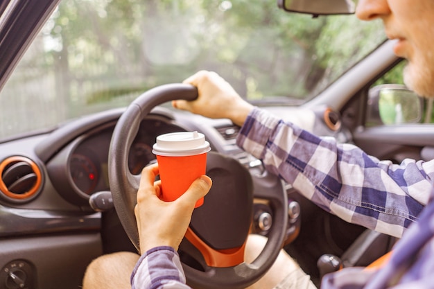 Beber café em copo de papel durante a viagem no carro