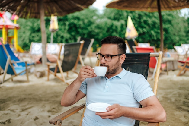 Beber café na praia.