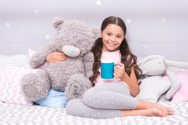 Beber leche justo antes de acostarse Bebida antes de acostarse Leche caliente antes de dormir Beneficios para la salud Beber agua antes de acostarse Niño pequeño sostener una taza Niña en pijama bebiendo té Relajación antes de dormir