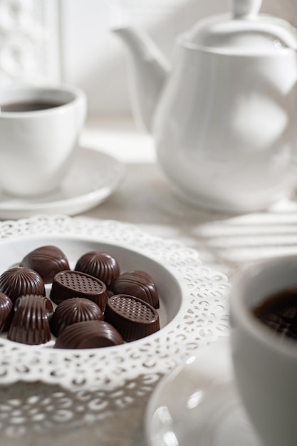 Beber té. La hora del té. Tetera blanca con tazas y un juego de bombones. Desayuno inglés