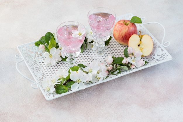 beber en vasos, manzanas y flores de manzano