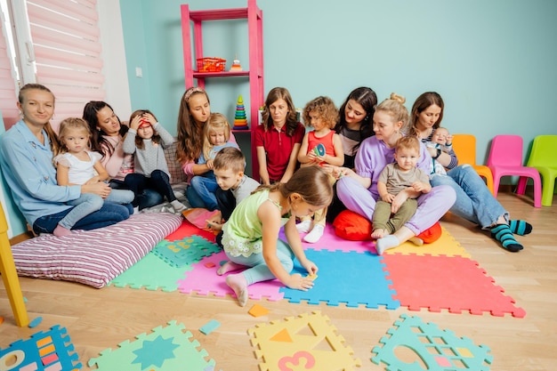 Bebês adoráveis e suas mães no berçário ou creche