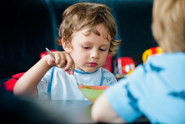 Bebês comendo comida saudável para um bebê garoto comendo comida saudável