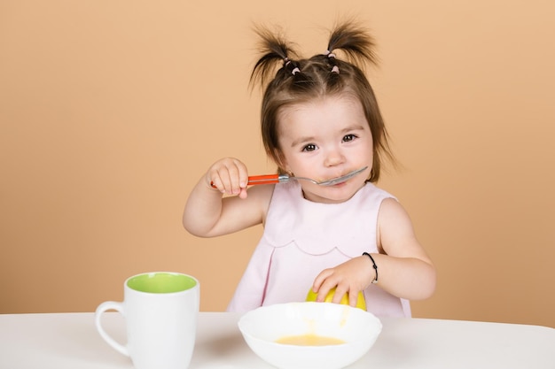 Bebés comiendo alimentos saludables para un bebé Pequeño bebé comiendo puré de frutas